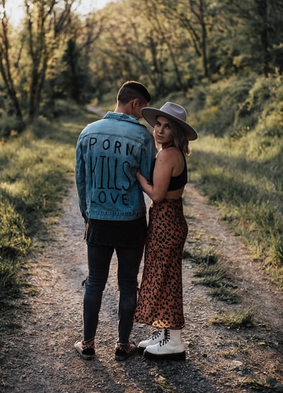 一对男女手牵着手走在土路上